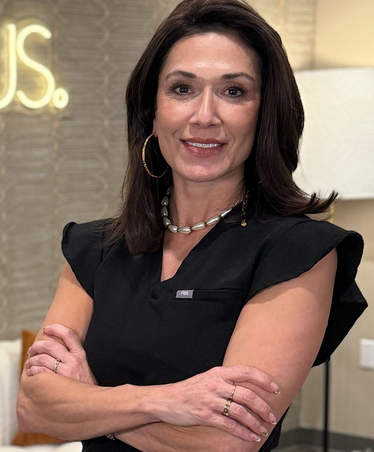 Professional woman with crossed arms and smile.