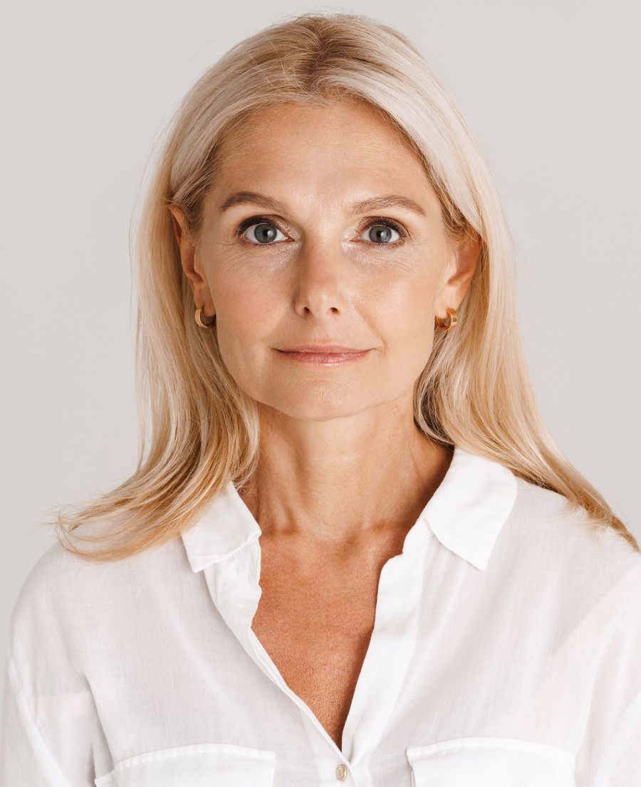 Woman with long blonde hair in white shirt.