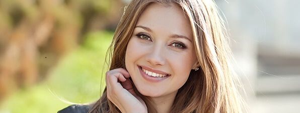 Smiling young woman with long, flowing hair.