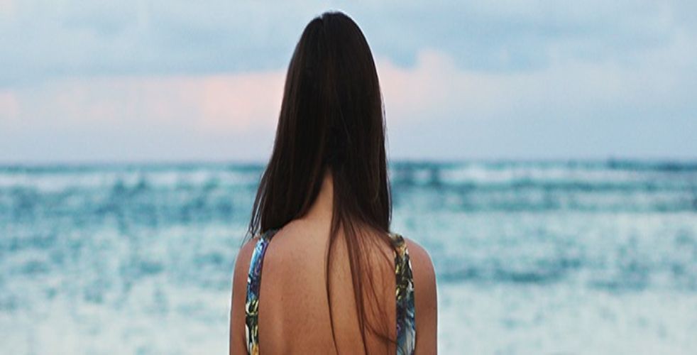 Woman with curly red hair looking back.