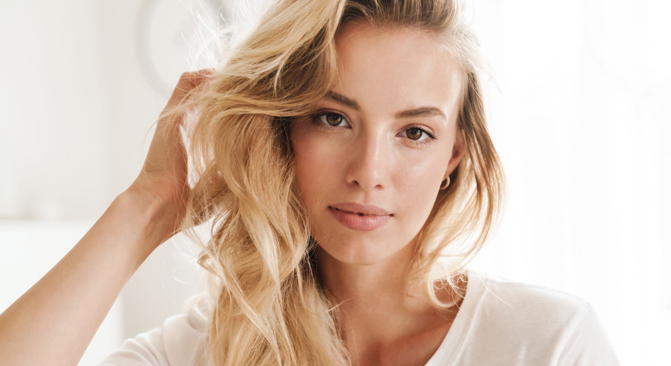 Woman with long wavy hair, natural makeup.