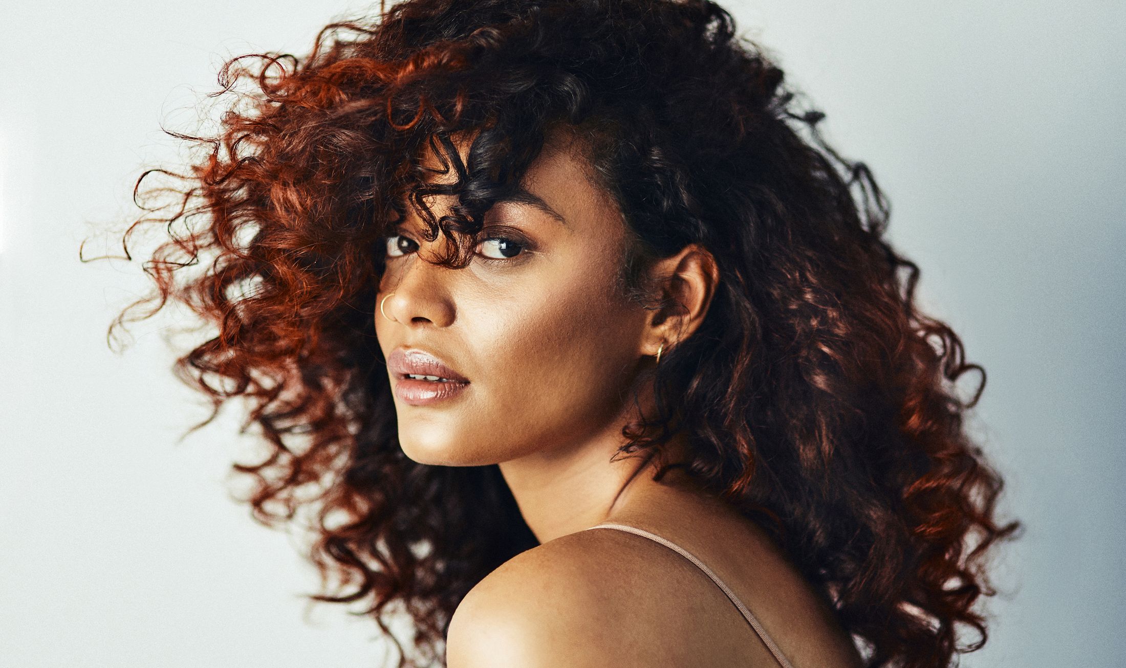 Woman with curly hair and natural makeup.